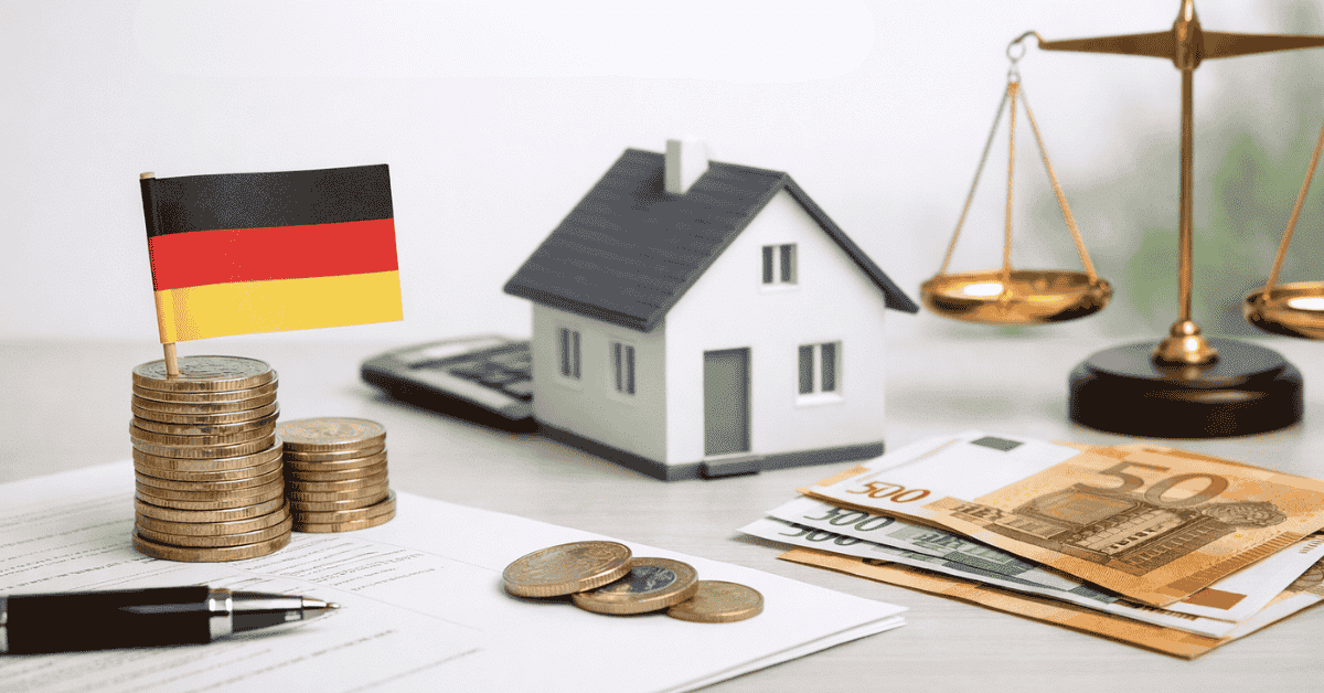 Symbolbild für Investitionen in Deutschland mit einer kleinen Deutschlandflagge auf Münzstapeln, einem Modellhaus, einem Taschenrechner, Euro-Banknoten und einer Waage im Hintergrund, das finanzielle Planung, Vermögensaufbau und ausgewogene Investitionsentscheidungen darstellt.